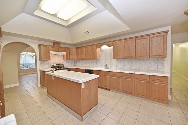 8037 E Morab Ave, Clovis, CA 93619 - kitchen with arched walkways, light tile patterned flooring, stainless steel stove, and backsplash