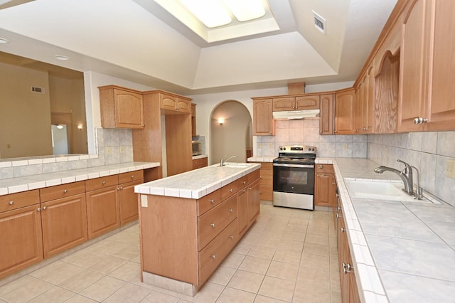 8037 E Morab Ave, Clovis, CA 93619 - kitchen featuring stainless steel range with electric stovetop, a raised ceiling, under cabinet range hood, and light tile patterned flooring