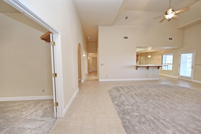8037 E Morab Ave, Clovis, CA 93619 - unfurnished living room with light tile patterned flooring, ceiling fan, arched walkways, and a high ceiling