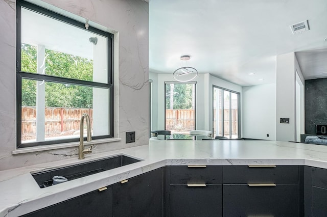 1292 E Valley Forge Dr, Fresno, CA 93720 - kitchen with dark cabinetry, modern cabinets, light stone countertops, and a peninsula