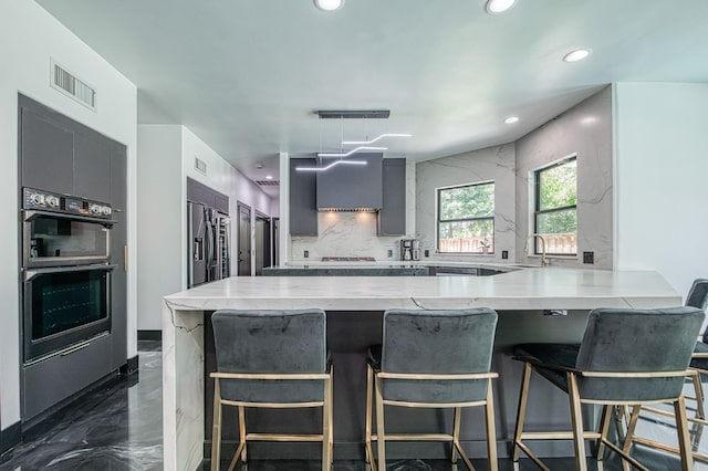 1292 E Valley Forge Dr, Fresno, CA 93720 - kitchen featuring high end fridge, a peninsula, recessed lighting, wall chimney range hood, and a kitchen breakfast bar