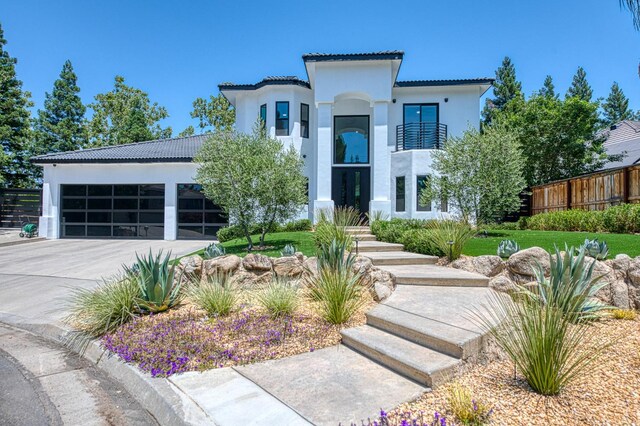 1292 E Valley Forge Dr, Fresno, CA 93720 - mediterranean / spanish house featuring stucco siding, a garage, concrete driveway, a tile roof, and a balcony