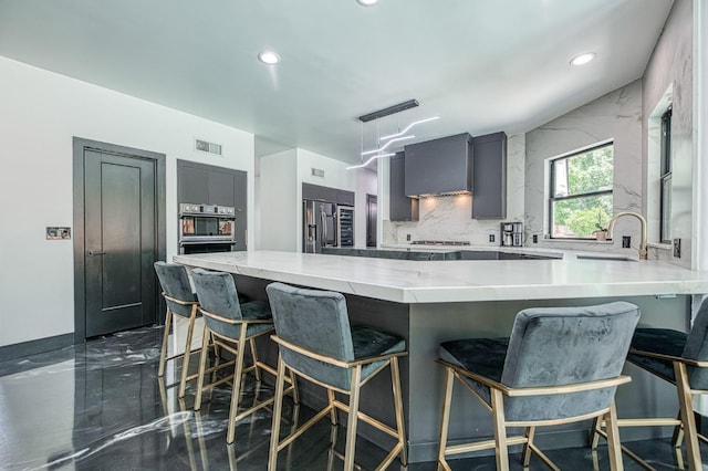 1292 E Valley Forge Dr, Fresno, CA 93720 - kitchen with stainless steel fridge, recessed lighting, a kitchen bar, a peninsula, and gray cabinetry