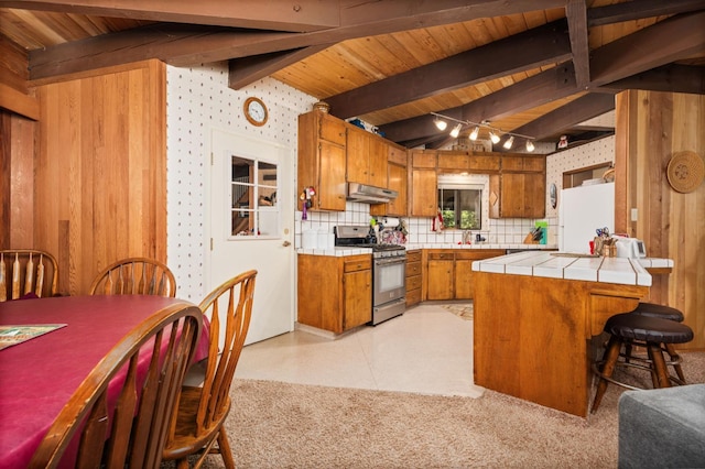 42215 Rock Ledge Rd, Shaver Lake, CA 96161 - kitchen with gas stove, brown cabinetry, freestanding refrigerator, tile countertops, and a wooden ceiling with exposed beams