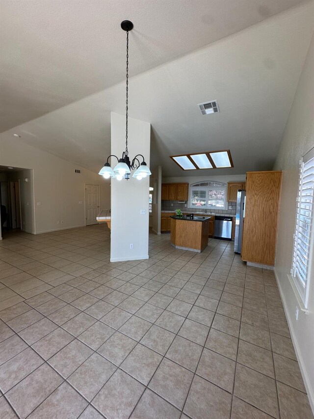 220 S Double Tree Way, Madera, CA 93637 - kitchen with open floor plan, vaulted ceiling, appliances with stainless steel finishes, a center island, and light tile patterned floors