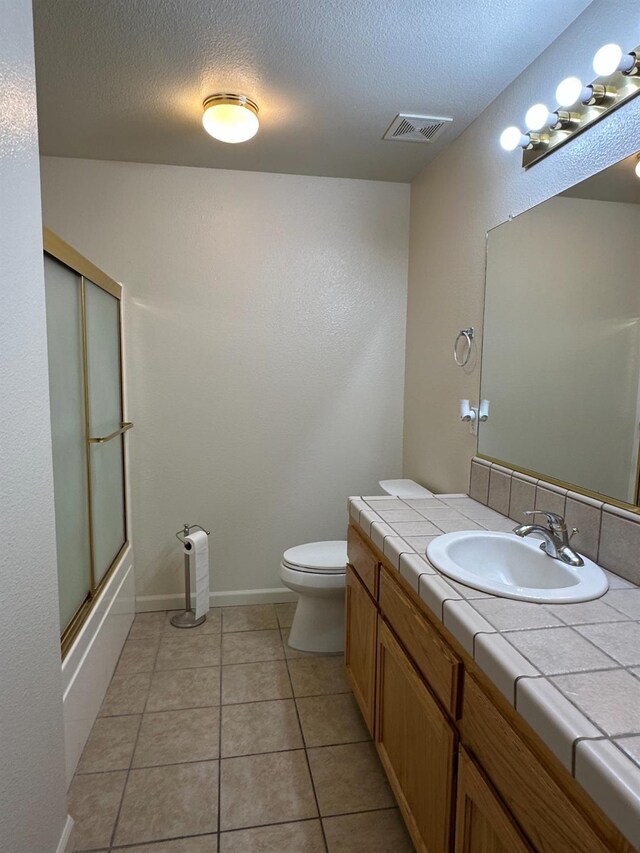 220 S Double Tree Way, Madera, CA 93637 - bathroom with vanity, a textured ceiling, tile patterned flooring, and combined bath / shower with glass door