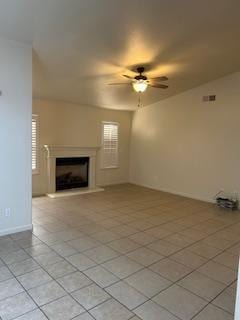 220 S Double Tree Way, Madera, CA 93637 - unfurnished living room with a fireplace with raised hearth, a ceiling fan, and light tile patterned floors