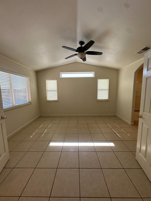 220 S Double Tree Way, Madera, CA 93637 - unfurnished room with lofted ceiling, ceiling fan, light tile patterned flooring, a textured ceiling, and arched walkways