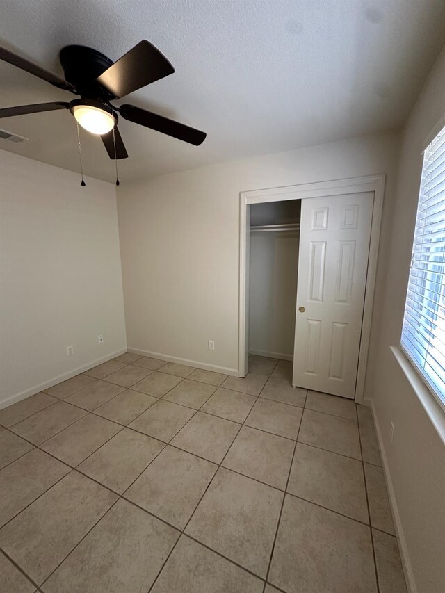 220 S Double Tree Way, Madera, CA 93637 - unfurnished bedroom with light tile patterned flooring, multiple windows, a closet, and a textured ceiling