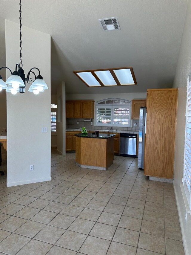 220 S Double Tree Way, Madera, CA 93637 - kitchen featuring appliances with stainless steel finishes, a kitchen island, backsplash, a chandelier, and light tile patterned floors