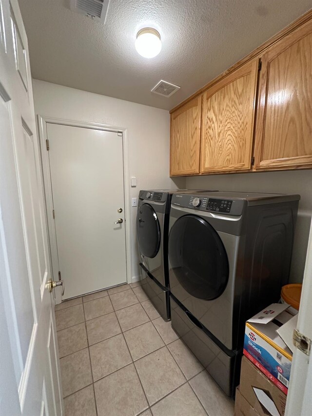 220 S Double Tree Way, Madera, CA 93637 - laundry room with a textured ceiling, washer and dryer, light tile patterned floors, and cabinet space