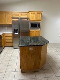 220 S Double Tree Way, Madera, CA 93637 - kitchen with stainless steel appliances, light tile patterned floors, tasteful backsplash, dark stone countertops, and a center island