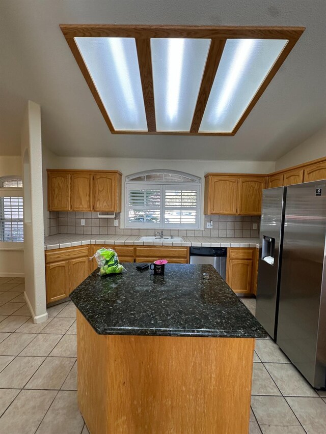 220 S Double Tree Way, Madera, CA 93637 - kitchen with stainless steel appliances, light tile patterned flooring, backsplash, lofted ceiling, and plenty of natural light