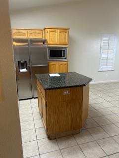 220 S Double Tree Way, Madera, CA 93637 - kitchen with appliances with stainless steel finishes, light tile patterned flooring, dark stone counters, and a kitchen island