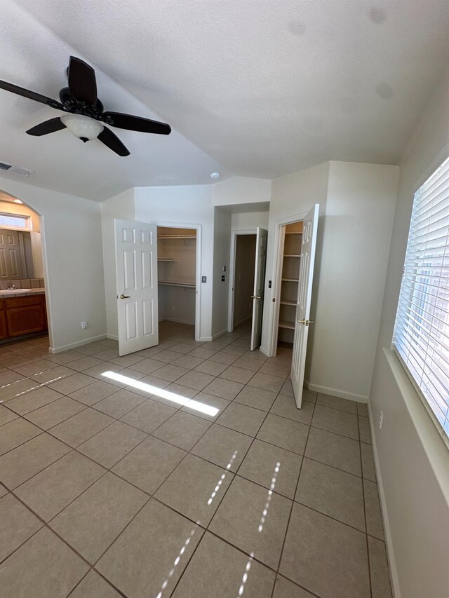 220 S Double Tree Way, Madera, CA 93637 - unfurnished bedroom with light tile patterned floors, arched walkways, and a ceiling fan