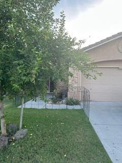 220 S Double Tree Way, Madera, CA 93637 - view of property exterior featuring driveway, a yard, and an attached garage