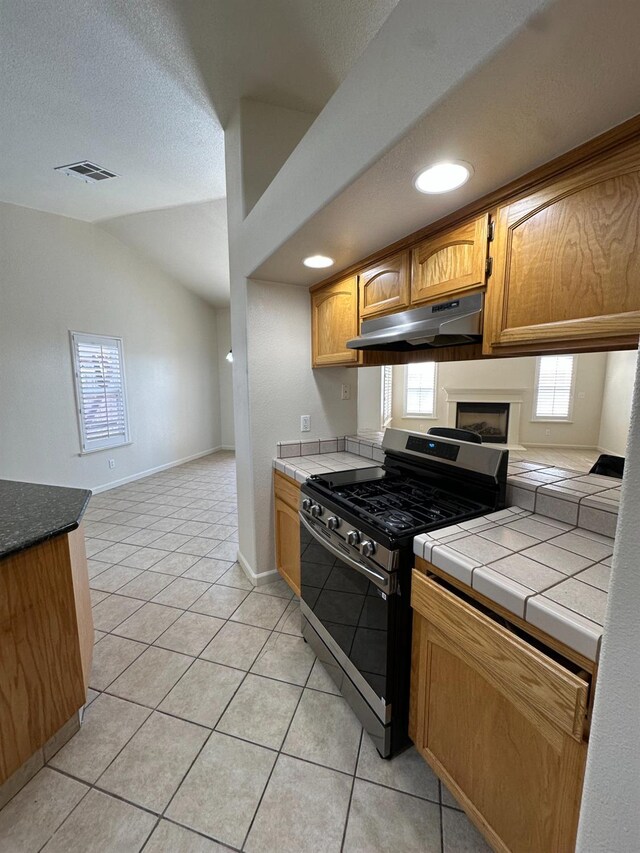220 S Double Tree Way, Madera, CA 93637 - kitchen featuring under cabinet range hood, gas range, healthy amount of natural light, light tile patterned floors, and lofted ceiling