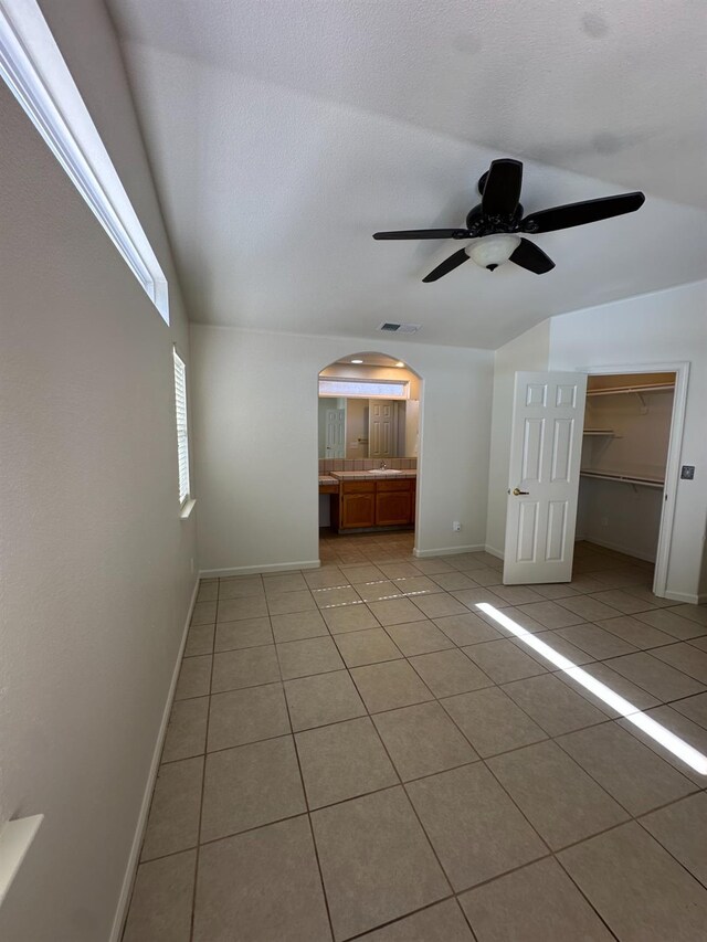 220 S Double Tree Way, Madera, CA 93637 - unfurnished living room featuring light tile patterned floors, arched walkways, ceiling fan, and vaulted ceiling