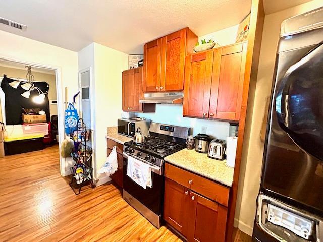 1445 E Cornell Ave, Fresno, CA 93704 - kitchen with stainless steel appliances, under cabinet range hood, and light wood-type flooring