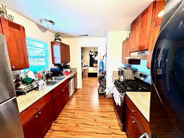1445 E Cornell Ave, Fresno, CA 93704 - kitchen featuring stainless steel appliances, under cabinet range hood, and light wood-type flooring