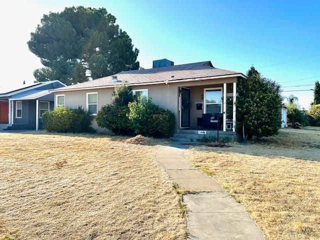 1445 E Cornell Ave, Fresno, CA 93704 - view of front facade featuring covered porch, stucco siding, and a front lawn