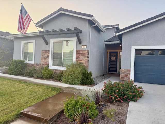 825 Spring St W, Madera, CA 93636 - view of front of home featuring stone siding, stucco siding, and an attached garage
