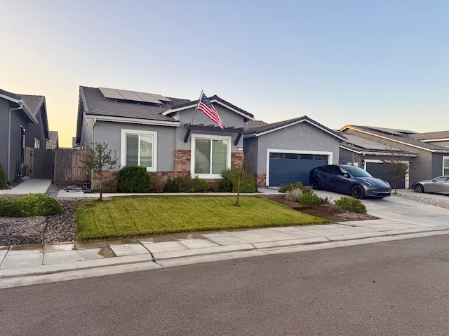 825 Spring St W, Madera, CA 93636 - ranch-style house with stucco siding, a garage, solar panels, driveway, and stone siding