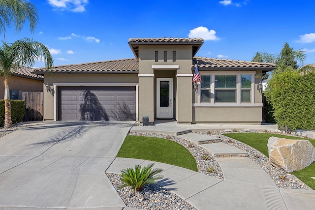 11337 N Cherry Sage Ave, Fresno, CA 93730 - mediterranean / spanish-style home featuring a garage, concrete driveway, stucco siding, and a tiled roof