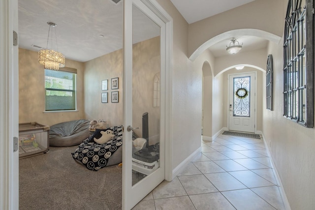 11337 N Cherry Sage Ave, Fresno, CA 93730 - foyer entrance with arched walkways, light tile patterned flooring, and a chandelier