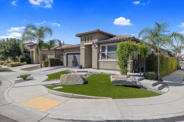 11337 N Cherry Sage Ave, Fresno, CA 93730 - mediterranean / spanish home with stucco siding, an attached garage, a tiled roof, driveway, and a front yard