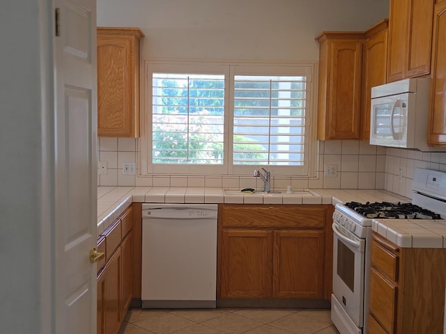 2300 Sierra St Unit 101, Kingsburg, CA 93631 - kitchen with white appliances, decorative backsplash, tile countertops, and light tile patterned flooring