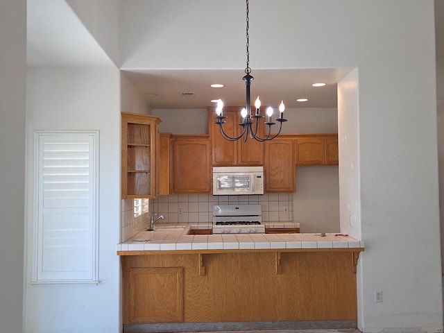 2300 Sierra St Unit 101, Kingsburg, CA 93631 - kitchen with white appliances, tile counters, decorative backsplash, and recessed lighting