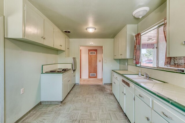 2120 Richard Ave, Sanger, CA 93657 - kitchen with tile countertops, decorative backsplash, electric stovetop, and white cabinets