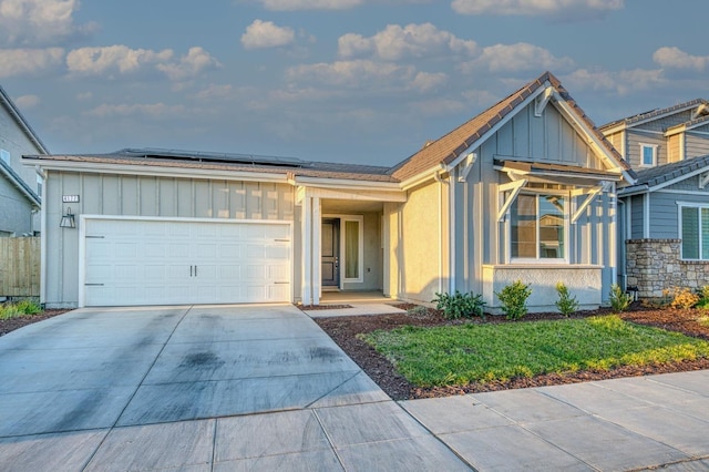 4177 Beverly Ave, Clovis, CA 93619 - ranch-style home featuring board and batten siding, roof mounted solar panels, driveway, and an attached garage