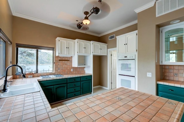 27415 Sky Harbour Rd, Friant, CA 93626 - kitchen with white double oven, tile countertops, tasteful backsplash, white cabinets, and gas stovetop