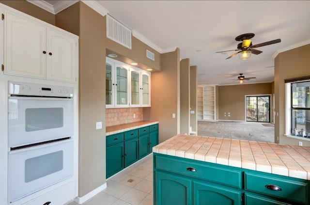 27415 Sky Harbour Rd, Friant, CA 93626 - kitchen featuring double oven, crown molding, ceiling fan, white cabinets, and tasteful backsplash