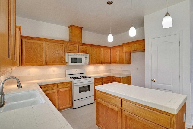 5684 W Holland Ave, Fresno, CA 93722 - kitchen with white appliances, brown cabinets, hanging light fixtures, and tile countertops