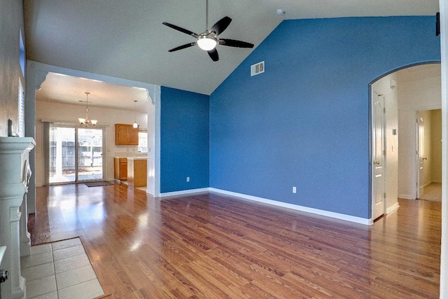 5684 W Holland Ave, Fresno, CA 93722 - unfurnished living room featuring ceiling fan, arched walkways, a chandelier, high vaulted ceiling, and wood finished floors