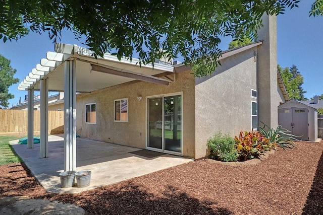 5684 W Holland Ave, Fresno, CA 93722 - back of property featuring a storage unit, a patio, and stucco siding