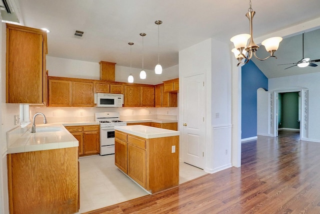 5684 W Holland Ave, Fresno, CA 93722 - kitchen featuring white appliances, ceiling fan, light wood-type flooring, a center island, and hanging light fixtures