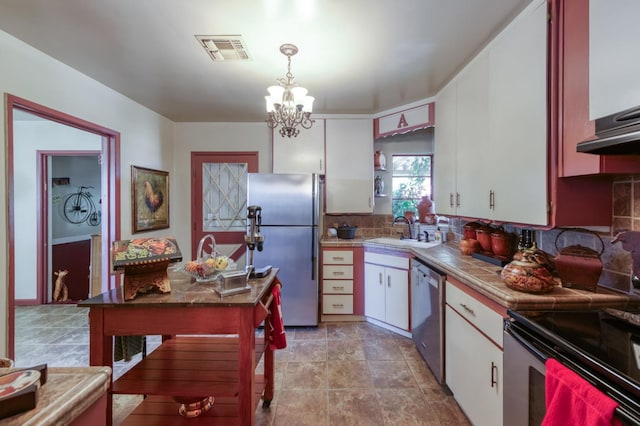 43125 Rd 80, Dinuba, CA 93618 - kitchen featuring stainless steel appliances, white cabinets, tasteful backsplash, a chandelier, and pendant lighting