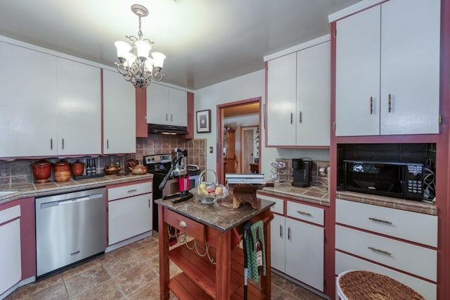 43125 Rd 80, Dinuba, CA 93618 - kitchen featuring stainless steel appliances, decorative backsplash, a chandelier, under cabinet range hood, and white cabinetry