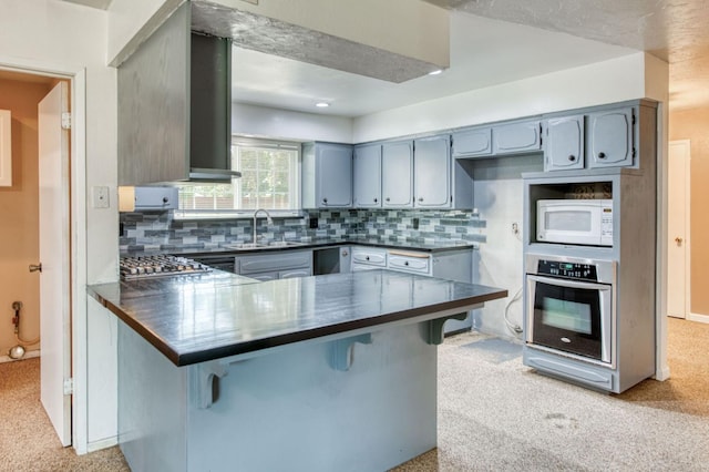 1580 Armstrong Ave, Clovis, CA 93611 - kitchen featuring appliances with stainless steel finishes, dark countertops, light colored carpet, a peninsula, and decorative backsplash
