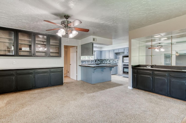 1580 Armstrong Ave, Clovis, CA 93611 - kitchen featuring oven, ceiling fan, a breakfast bar area, light colored carpet, and a textured ceiling