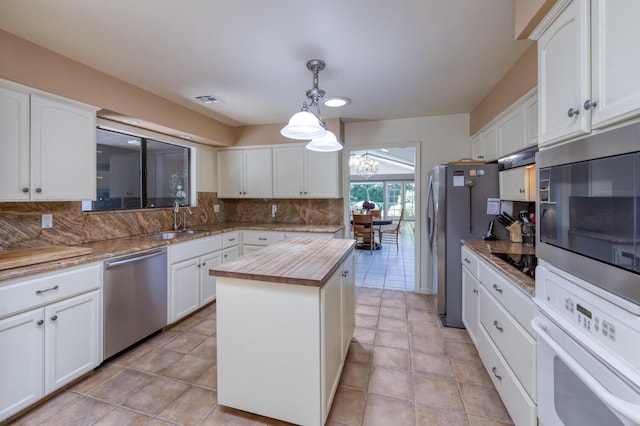 5039 N Van Ness Blvd, Fresno, CA 93711 - kitchen featuring appliances with stainless steel finishes, wood counters, decorative backsplash, and white cabinetry
