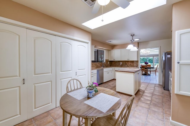 5039 N Van Ness Blvd, Fresno, CA 93711 - kitchen featuring a skylight, ceiling fan, appliances with stainless steel finishes, tasteful backsplash, and a center island
