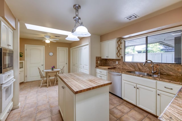 5039 N Van Ness Blvd, Fresno, CA 93711 - kitchen featuring wooden counters, appliances with stainless steel finishes, white cabinetry, and backsplash
