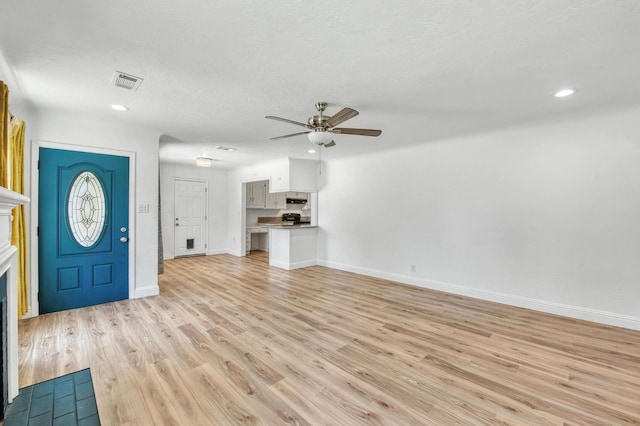 4611 N Safford Ave, Fresno, CA 93704 - entryway with ceiling fan, light wood finished floors, a fireplace, recessed lighting, and a textured ceiling