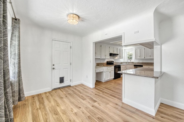 4611 N Safford Ave, Fresno, CA 93704 - kitchen featuring electric range, light wood-style floors, a peninsula, under cabinet range hood, and a textured ceiling