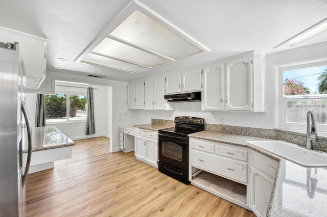 4611 N Safford Ave, Fresno, CA 93704 - kitchen featuring black range with electric stovetop, under cabinet range hood, light wood-type flooring, white cabinets, and freestanding refrigerator
